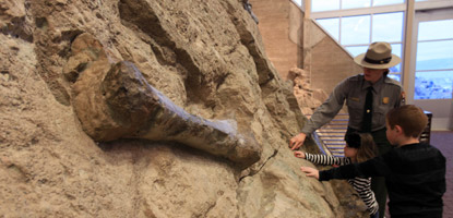 A park ranger helps kids get up close and personal to dinosaur fossils at Dinosaur National Monument.