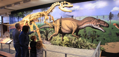 A family takes a look at an allosaurus replica and mural in the Quarry Exhibit Hall A family takes a look at an allosaurus replica and mural in the Quarry Exhibit Hall