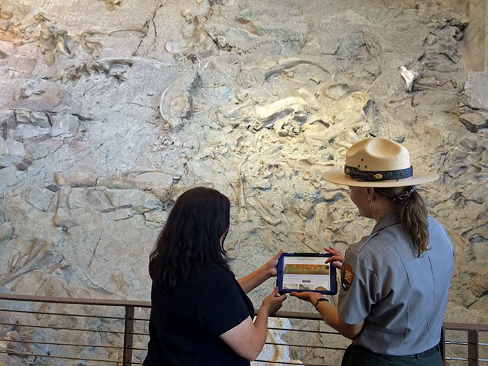 A ranger and visitor looking at the digital quarry project on an Ipad