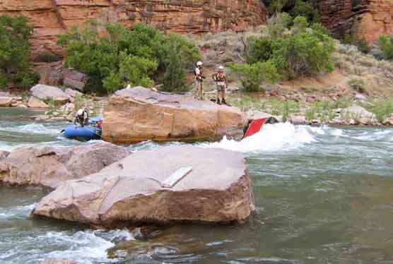 Dinosaur National Monument ranger Doug Ross secures raft to Winnie’s Rock, while rangers Phil Dendel and Matt Gilbert discuss safety precautions.