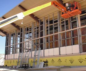 Crew in a man lift work on installing framing for south curtain wall at the Quarry Exhibit Hall. 