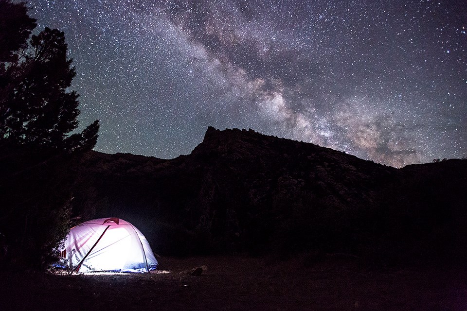 Lighted tent underneath a starry sky
