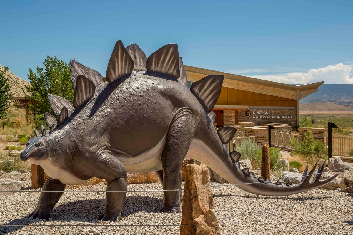A statue of a brown stegosaurus stands just outside the Quarry Visitor Center on the Utah side of the park.