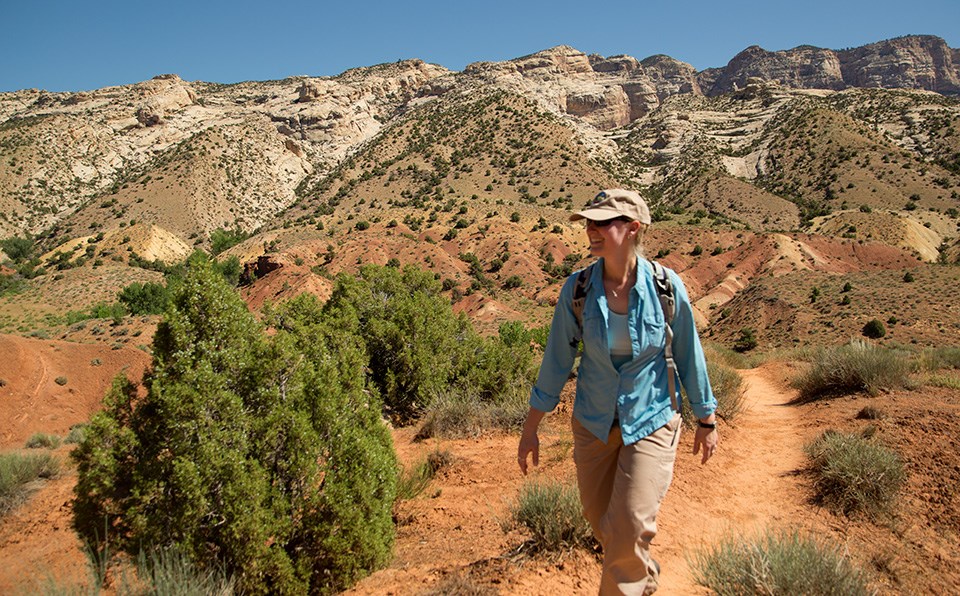 Woman hiking with mountains in the background.