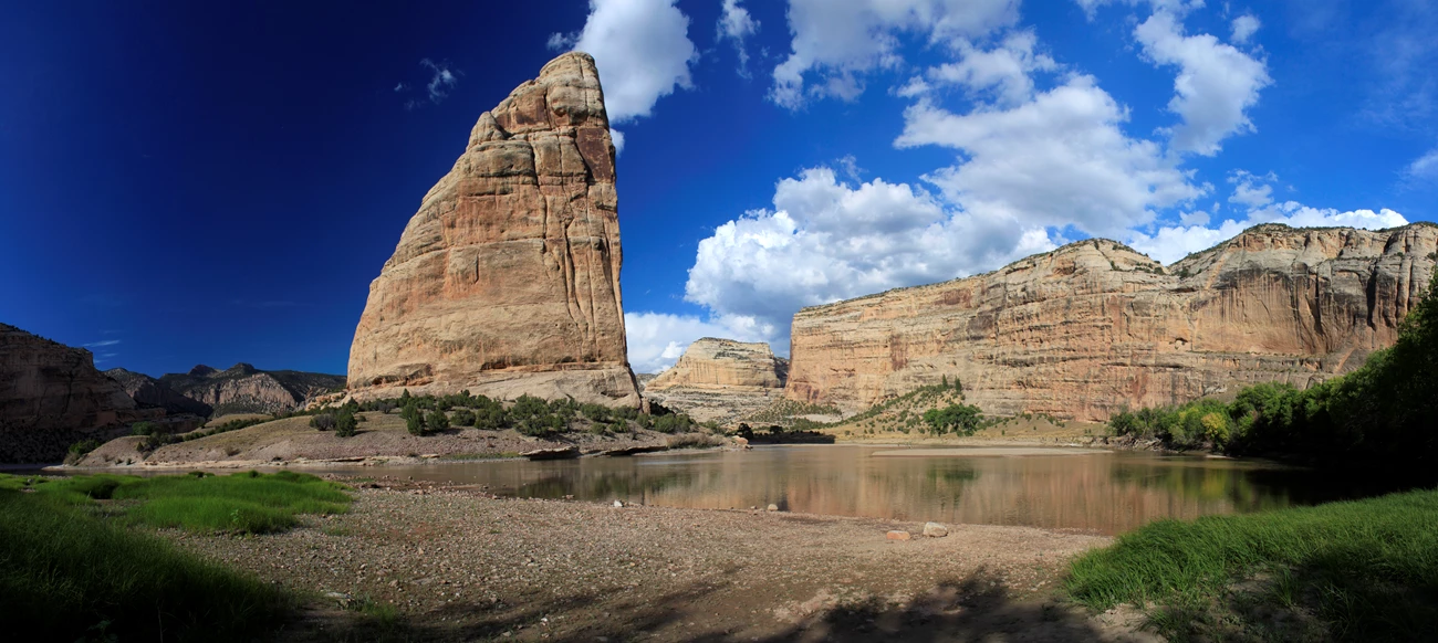 Steamboat Rock in Echo Park Large tan cliffs rise above a river.