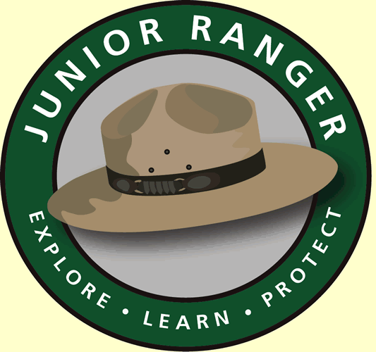A logo with a green ring around a tan ranger flat hat, that reads "Junior Ranger, Explore, Learn, Protect"