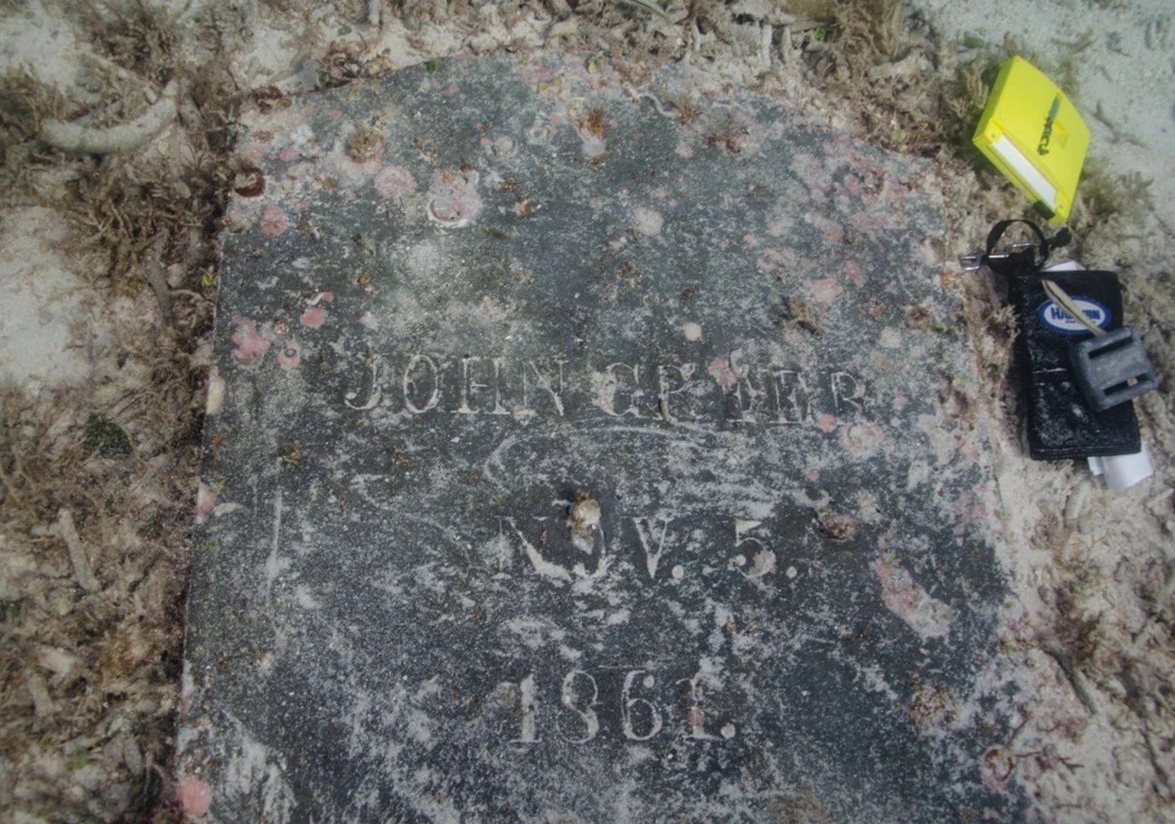 Underwater headstone of John Greer NPS Photo C Sproul A gravestone with sand shows the inscription "John Greer. Nov. 5. 1861."