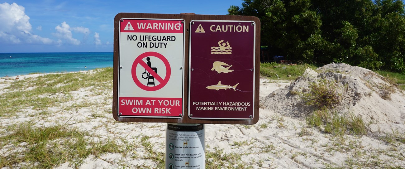 Two safety signs on the beach