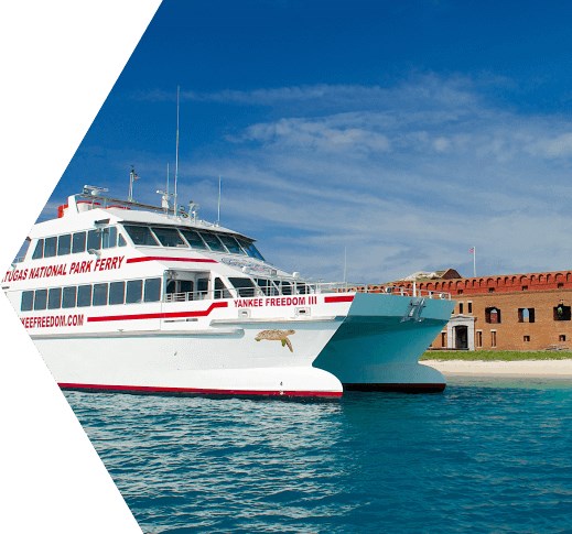 a large white ferry boat with red lettering docked in turquoise blue water