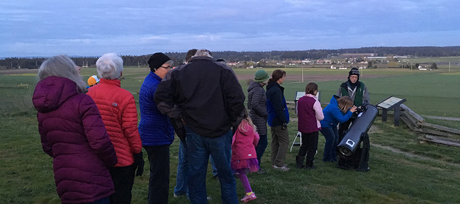 Group waits in line to use a telescope. Group waits in line to use a telescope.