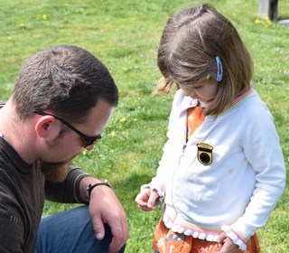Father helps his daughter pin on an Ebey's Jr Ranger Badge Father helps his daughter pin on an Ebey's Jr Ranger Badge