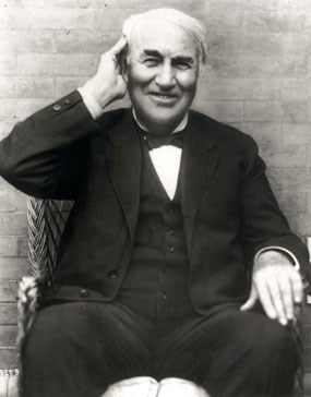 Thomas Edison holding his right hand to his right ear.