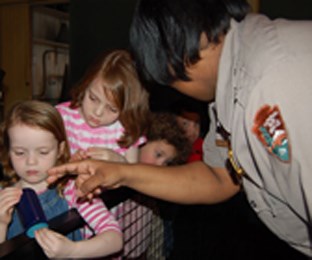 Park Ranger showing an early Edision cylinder record to a group of students.