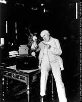 Edison with his motion picture projector in the library.