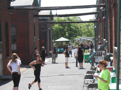 Visitors walking around the laboratory courtyard visiting different event activities.