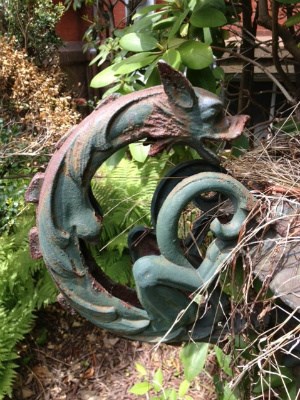 Rusty metal planter showing a close up of a dragon shaped decorative handle located at Glenmont.