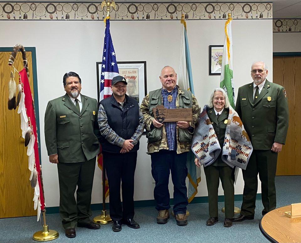 National Park Service and Ioway Tribal National Park leaders announce sister park agreement. National Park Service and Iowa Tribe of Kansas and Nebraska leaders hold plaque recognizing sister park agreement.