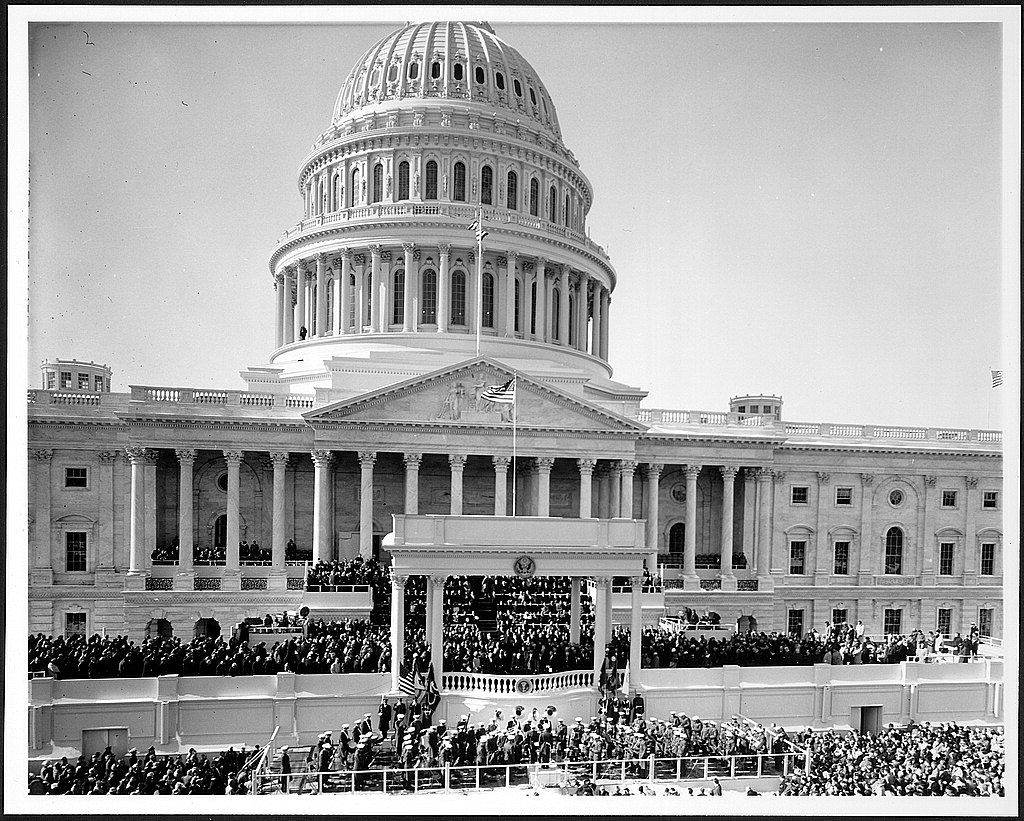 Hundreds gather on the stairs and portico of the large white domed US Capitol Building for the Inauguration of President John F. Kennedy