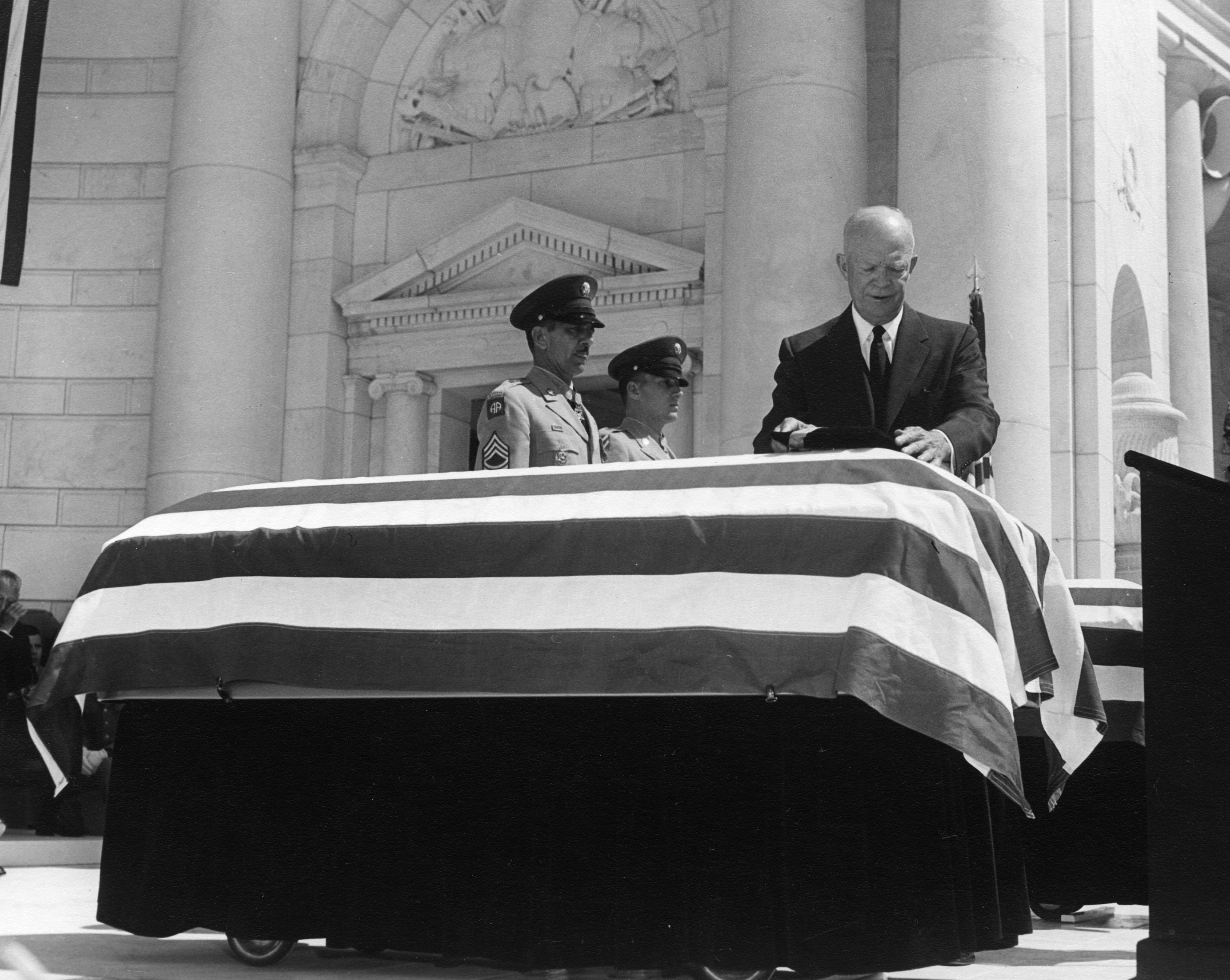 President Eisenhower Places Medals On Top of Two Flag Draped Caskets