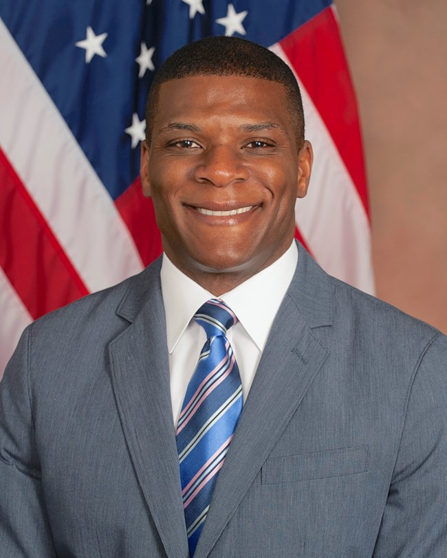 A man in a suit smiles for a photograph