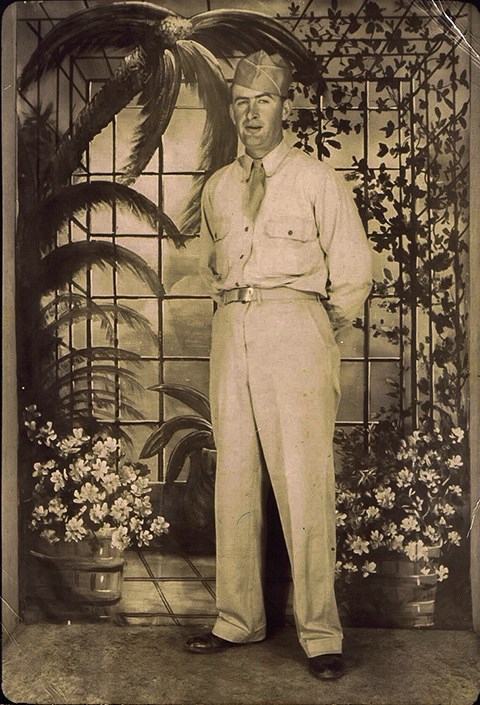 A black and white photo of Charles Henry Seaton in front of a tropical backdrop.