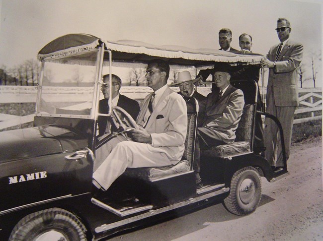 Historic image of Dwight Eisenhower, Winston Churchill, and Secret Service agents driving around the president's farm