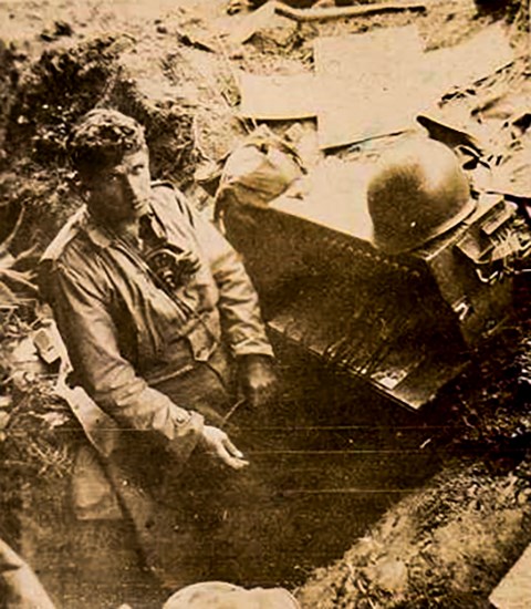 A black and white photo of Theodore C. Schmidt next to his radio equipment in the field.