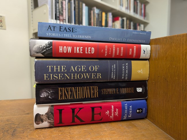 A stack of books with colorful bindings on a wood cart