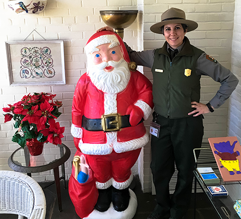 A staff member stands with a life-sized Santa Claus on the porch of the Eisenhower home. A staff member stands with a life-sized Santa Claus on the porch of the Eisenhower home.