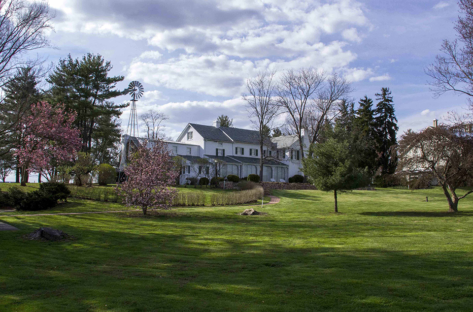 The Eisenhower home as seen in the spring. Green grass is in the foreground and blue skies are visible on the horizen.