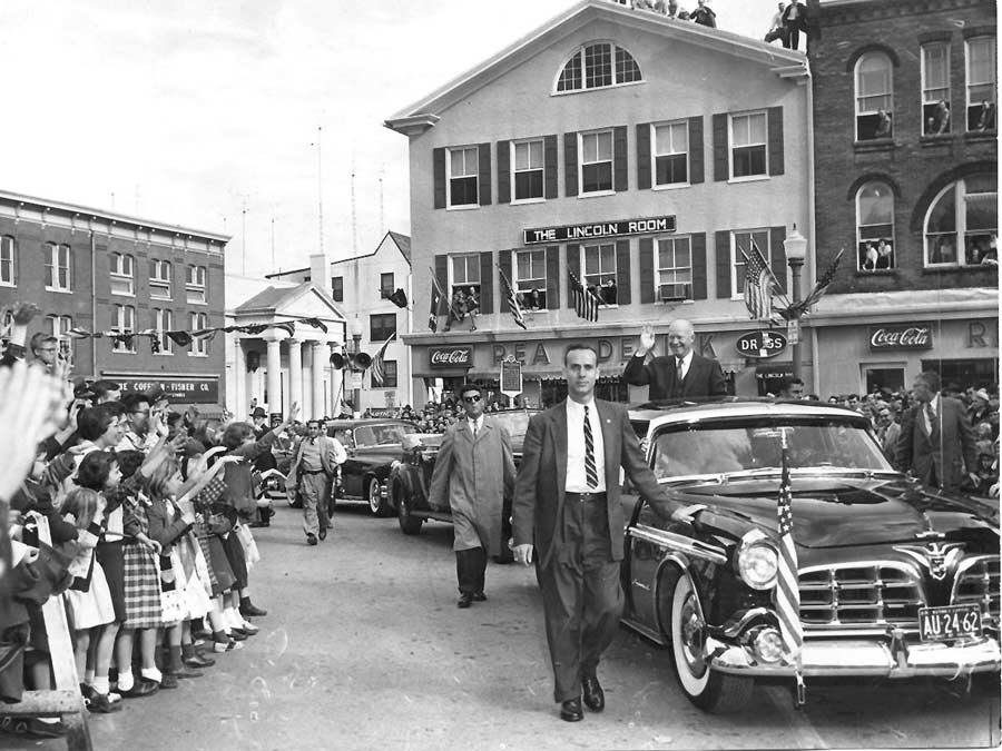 President Eisenhower being driven in his Chrysler Imperial limo greets onlookers in Gettysburg's Lincoln Square on November 14, 1955