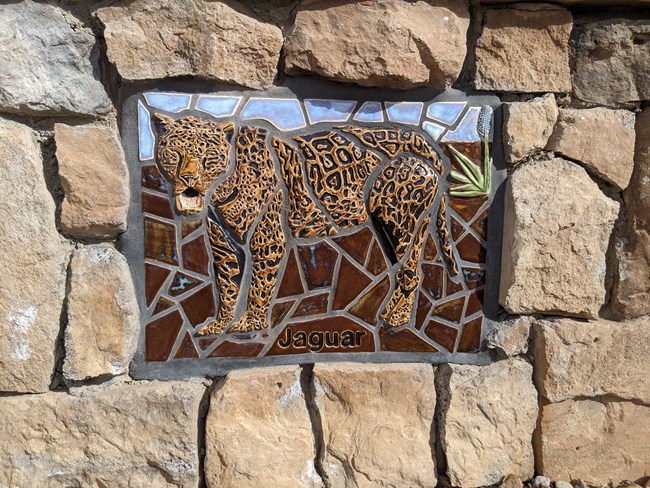 Jaguar Mosaic Jaguar Mosaic The mosaics on the wall up to the “high road” represent the things travelers may have seen as they traveled the 1600 miles on El Camino Real de Tierra Adentro. As you walk along the path, look for the twelve art pieces.