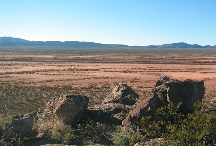 rocky ledge above a vast red landscape