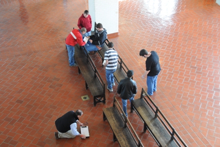 Students take measurements of benches in Ellis Island's Great Hall. They will then make 'replicas' of the benches for a school project and donate them to the park.