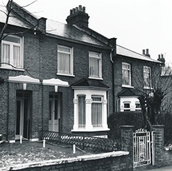 Three brick two story row house viewed from the street