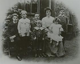 Avis Hope, seated and surround by her six children, facing the camera