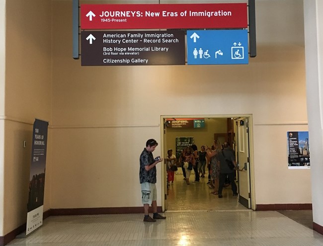 A picture of signage for finding accessible elevators inside Ellis Island's museum.