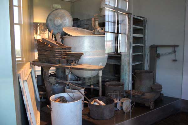 Exhibit case containing food service items from Ellis Island's period of abandonment.