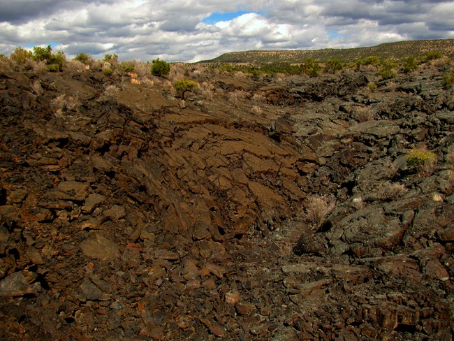 Rounded mounds of cracked slabs of rock surrounded by rubble.