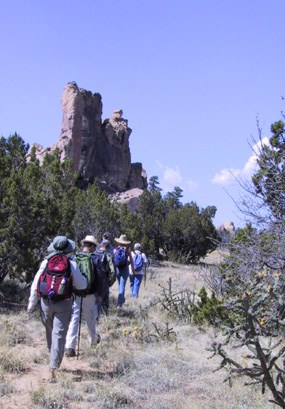 Hikers trek past sandstone buttes in El Malpais. Hikers trek past sandstone buttes in El Malpais.