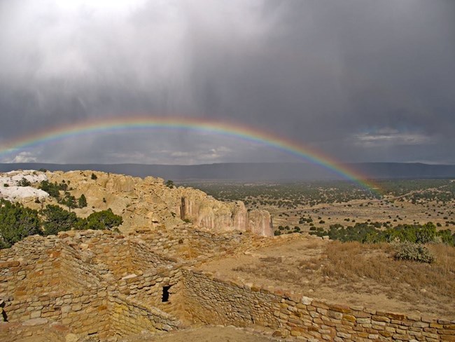 A rainbow over a pueblo structure.