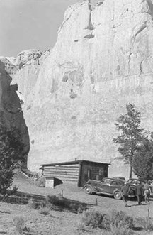 Historic images of a small wooden structure with a truck in front.