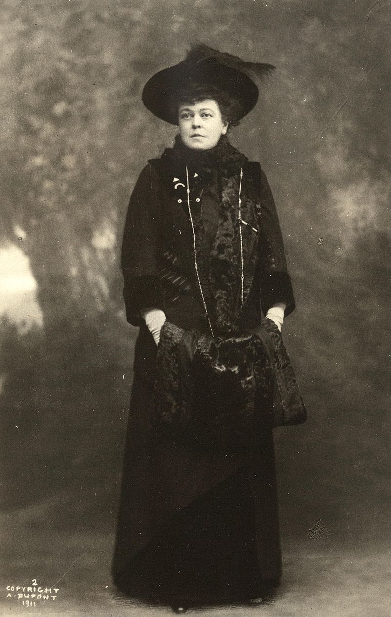 A woman (Alva Vanderbilt Belmont) in a black feathered hat and black dress.