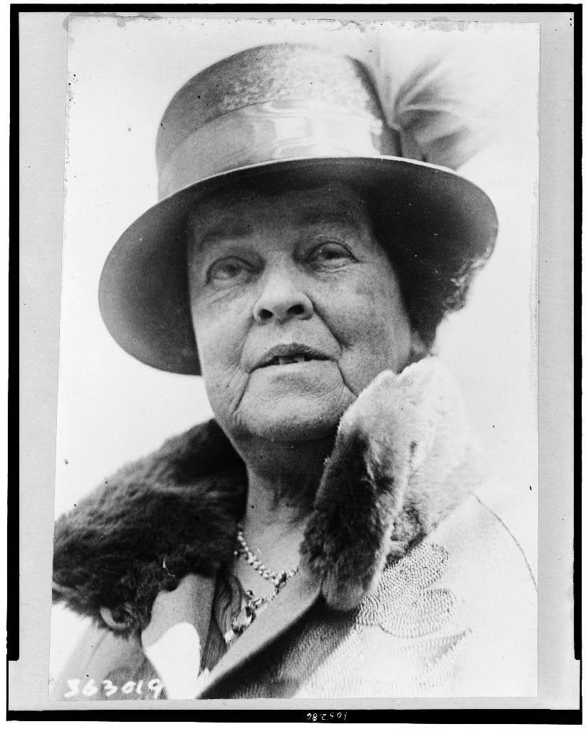 A woman wearing a fur-collared coat and a hat.