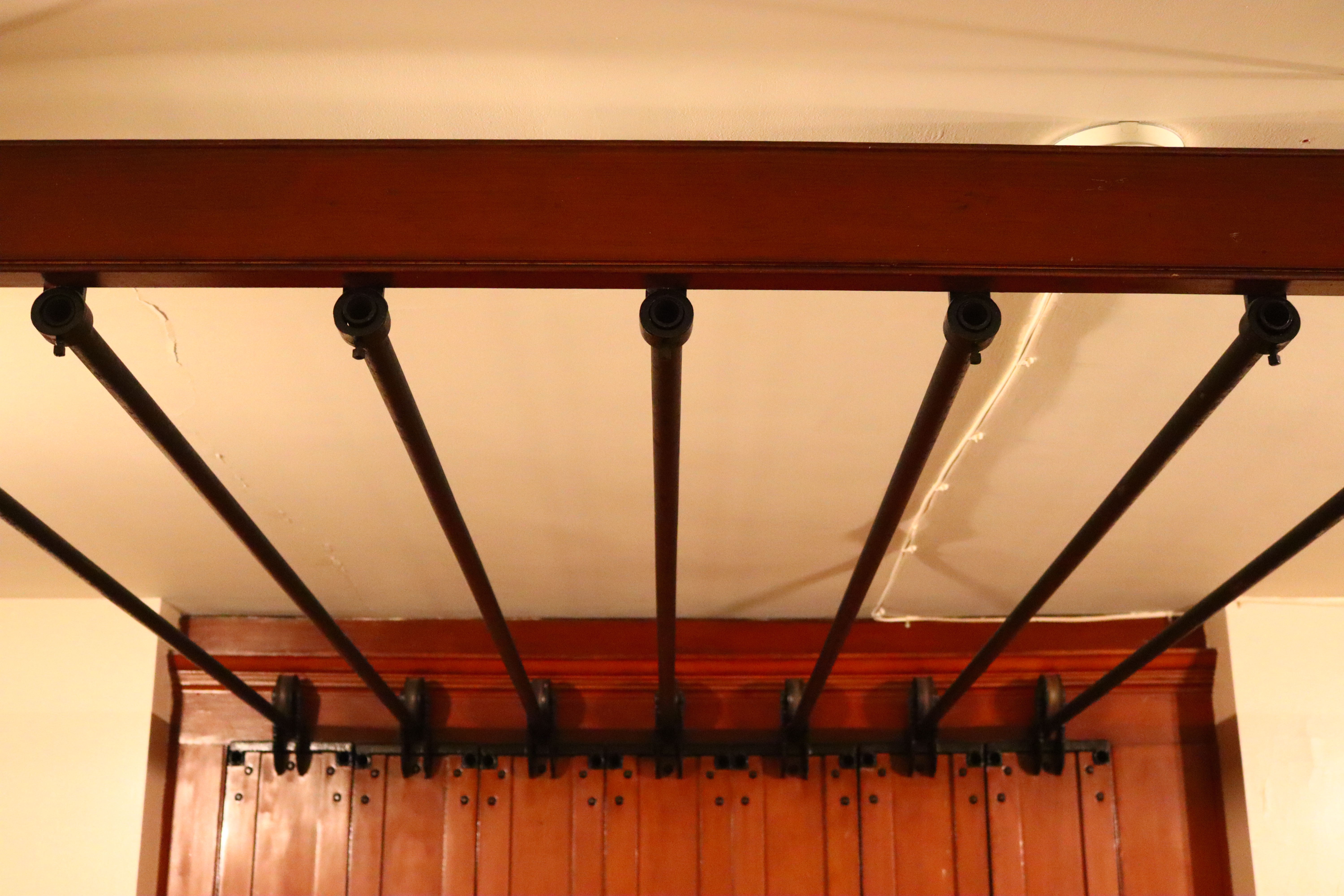 Metal rails suspended by a wooden bracket and a wall.