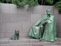 Metal statues of a man, seated, and a dog