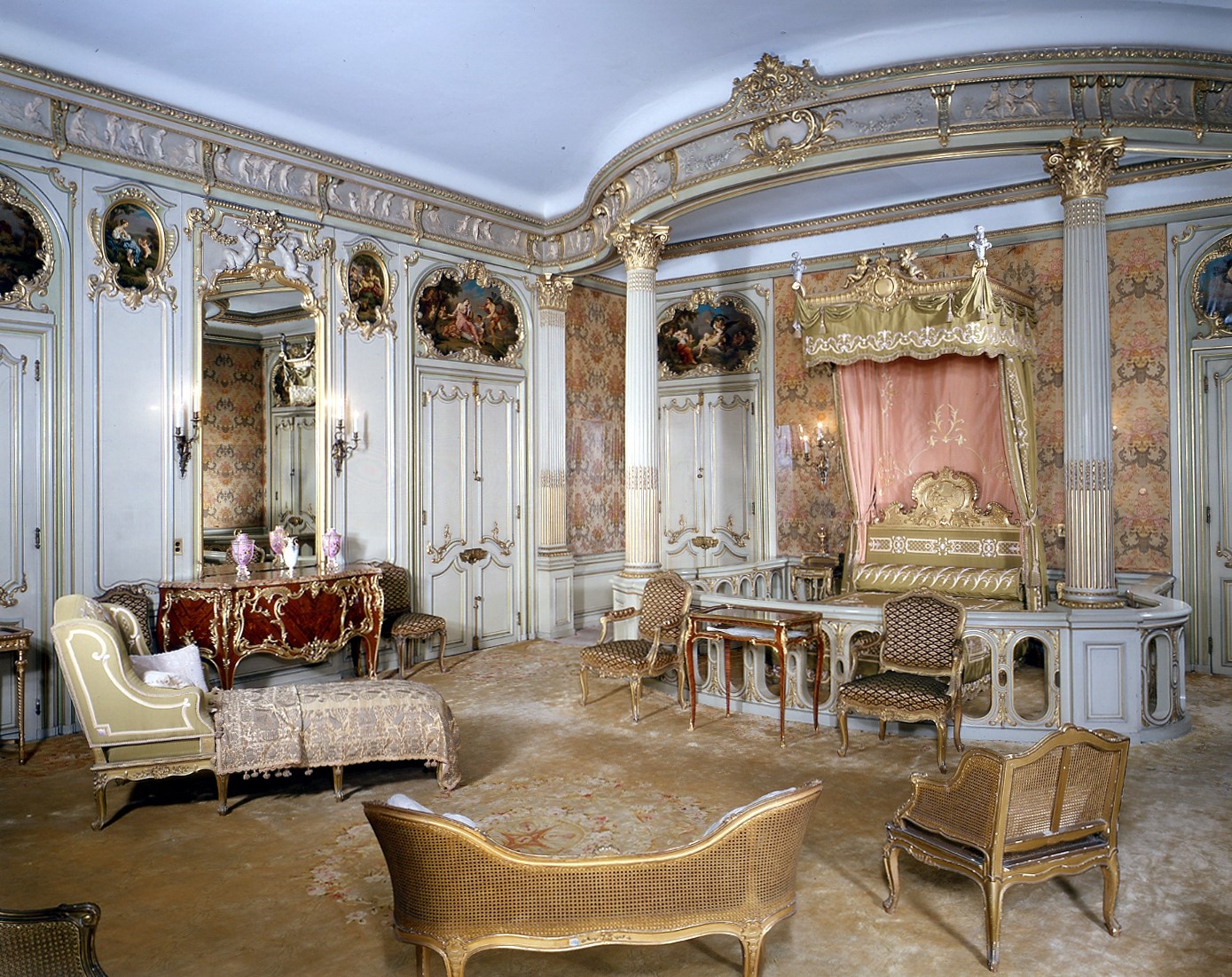 A room with white and gold walls and white and gold furniture.