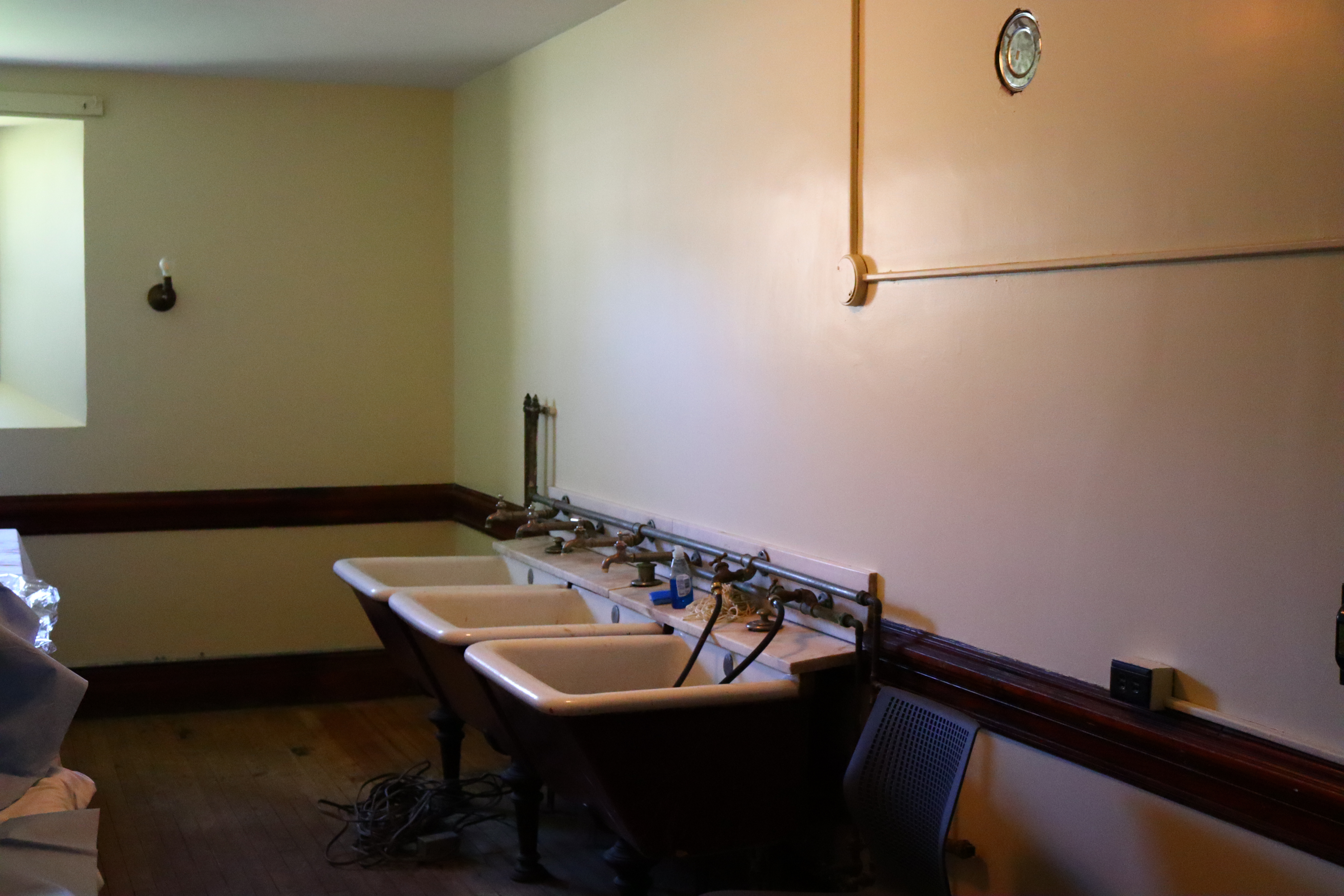 A set of three porcelain wash tubs in a white room.