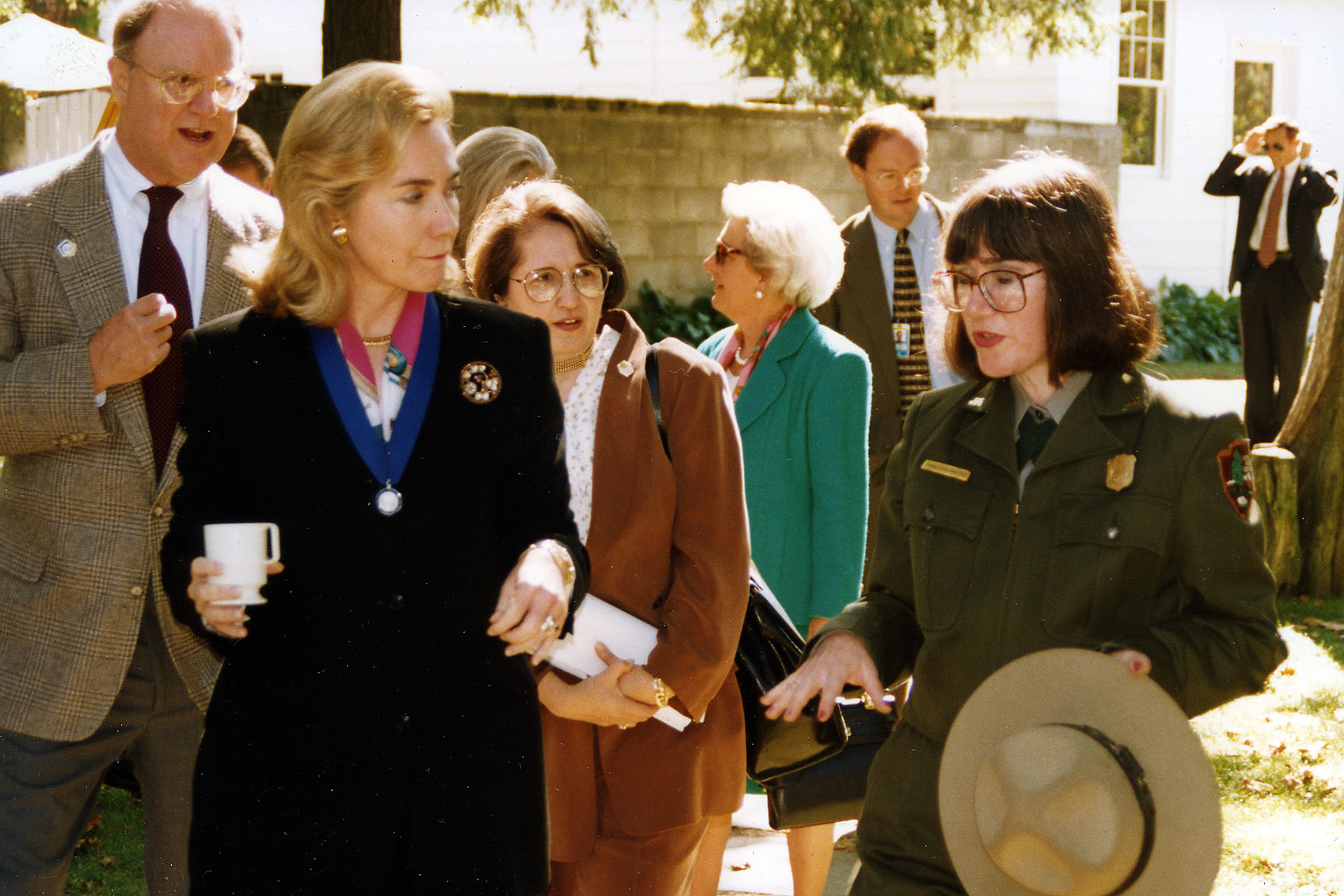 Two women stand in front of a group of people