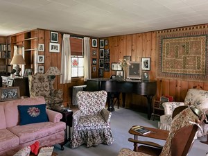 A paneled room with baby grand piano.